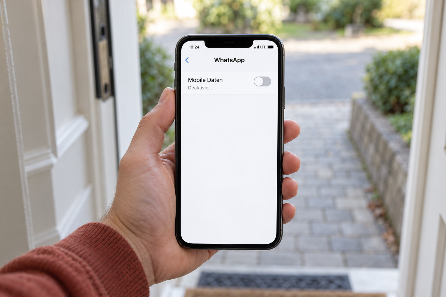 Symbolbild: Smartphone an einer Haustür mit deaktivierten mobilen Daten für WhatsApp bei angezeigter LTE-Verbindung.